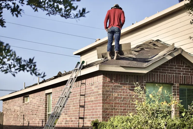 Professional roofer working on a residential roof in Bartlett Estates